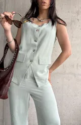 Chaleco verde agua con escote en V, sin mangas y cierre frontal con botones.