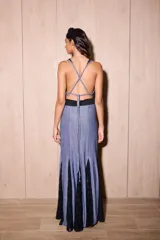 Vestido largo de silueta fluida, entallado en el torso, con escote profundo en V y espalda descubierta con tiras cruzadas. El cuerpo del vestido es de tejido jersey con lurex azul, y la falda presenta paneles triangulares de encaje negro con diseño de lunares.