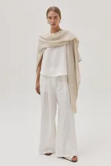 Ruana beige de tejido de punto calado con diseño de rayas verticales.