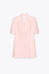 Blazer color rosa confeccionada en lino, con cuello solapa, manga corta con hombreras, bolsillos delanteros con solapa, cintura entallada y cierre frontal con botones.