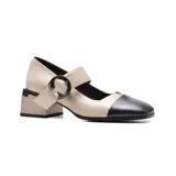 Zapato de vestir de cuero color beige y negro, con correa sobre el empeine y hebilla decorativa. Taco cuadrado.