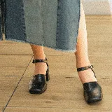 Zapato de cuero vacuno color negro con textura croco, con talón cubierto, pulsera con hebilla y taco de madera forrado en cuero.