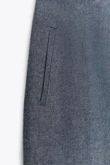 Pantalón culotte gris de tiro alto con bolsillos delanteros de vivo. Pierna ancha y cierre frontal con cremallera y gancho metálico.