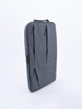 Mochila gris con múltiples bolsillos con cierre y asa superior. Ideal para transportar una laptop y otros objetos personales.