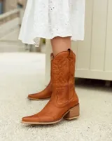 Bota texana de cuero color marrón, con caña media, punta fina y taco de madera.