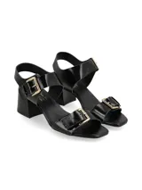 Sandalias negras de charol con hebillas metálicas doradas y taco cuadrado.