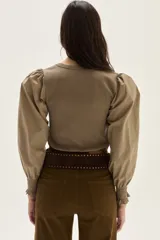 Top negro de calce al cuerpo con escote cuadrado amplio. Mangas largas abullonadas con puños elastizados.