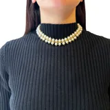 Gargantilla doble con perlas plásticas y detalles en acero dorado.