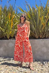 Mono largo de fibrana con estampado abstracto en tonos rojo y blanco, con breteles finos y corte palazzo.