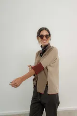 Sweater beige de lana lambswool con escote en V, mangas al codo y tajos laterales. Tiene terminaciones en color bordó.