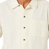 Camisa beige de manga corta con rayas verticales, cuello clásico y bolsillo en el pecho. Cierre frontal con botones. Marca Rip Curl, modelo Raw Energy Stripe.