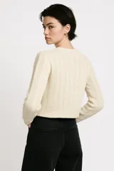 Sweater color crudo de acrílico con ochos, corte holgado y cuello redondo.