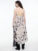 Vestido largo de breteles finos confeccionado en viscosa crinkled con estampa de manchas. De escote en V y silueta evasé, tiene una caída fluida que acompaña el movimiento. El efecto arrugado del tejido le da textura y carácter a una prenda fresca y versátil.