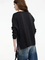 Sweater de hilo color gris con textura brillosa, escote en V y manga larga.