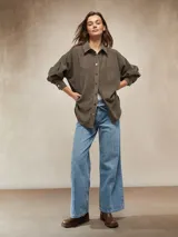 Pantalón de jean negro de tiro alto, corte ancho y pierna recta, con costuras verticales marcadas en el frente y cordón ajustable en la cintura.