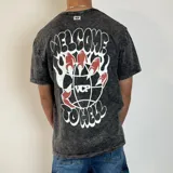Remera negra con efecto acid wash y estampado en la espalda con la frase "Welcome to hell" y una mano con garras sobre un globo terráqueo.