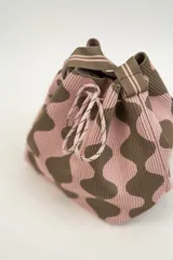 Bolso tipo bombonera tejido a crochet, con patrón geométrico en tonos rosa y marrón. Tiene cierre con cordón ajustable y correa de hombro.