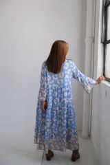 Vestido midi celeste con estampado de manchas beige, cuello mao, mangas 3/4 acampanadas y corte escalonado.