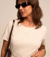 Vestido corto color crema, de corte recto, con cuello redondo y mangas cortas. Incluye cinturón fino con hebilla.