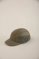 Gorro tipo cap verde con paneles de diferentes texturas y etiqueta con logo en el lateral.