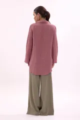 Camisa de manga larga, color rosa viejo, con cuello camisero y botones frontales. Presenta un calce holgado.
