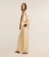 Blazer oversized color beige confeccionado en viscolino, con solapas en el cuello, botones delanteros y solapas delanteras que simulan bolsillos.