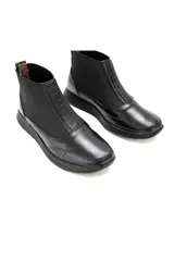 Botín Chelsea negro de cuero vacuno liso con inserciones elásticas laterales y detalle texturizado en el talón.
