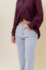 Jean de corte wide leg en color azul medio, con tiro medio, diseño de pierna amplia y fluida, y cinco bolsillos funcionales.