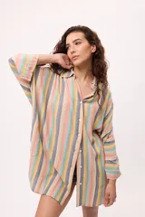 Vestido camisero a rayas verticales de colores pastel, con cuello camisero, cierre frontal con botones y mangas largas.