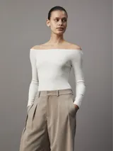 Remera color crema de corte ajustado, con textura de canalé y escote bardot.