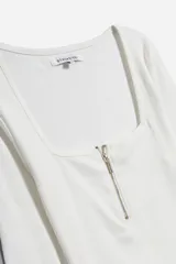 Remera de manga larga color mostaza, confeccionada en tejido acanalado, con escote cuadrado y cierre frontal metálico dorado.