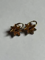 Par de aros dorados con dije de estrella de seis puntas.