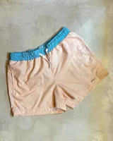 Short de baño color durazno con cintura elástica celeste y cordón ajustable blanco.