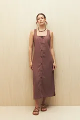 Vestido largo sin mangas color marrón, con escote cuadrado y abotonadura frontal completa. Corte recto con leve abertura en el ruedo.