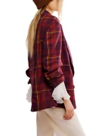 Blazer cruzado de corte oversize, con solapas amplias y hombros estructurados. Presenta un estampado tartán en tonos burdeos, morado y amarillo.