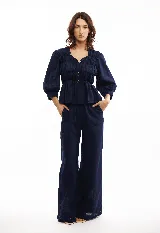 Pantalón marrón de lino, de corte amplio y cintura elástica con cordón ajustable.