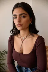 Collar con dije plateado en forma de cráneo de toro y tiento encerado marrón.