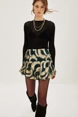 Falda corta con volados, tiro alto, confeccionada en tejido lurex con estampado abstracto en tonos verde oscuro y dorado.