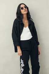 Pantalón recto negro de algodón con bordado artesanal blanco a contratono en los laterales y ruedo.