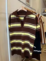 Vestido tejido marrón con rayas horizontales amarillas y blancas, cuello polo y mangas cortas.