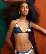 Traje de baño de dos piezas con estampado de rayas acuareladas. El top es triangular con breteles anchos fijos, lazo en la espalda y copas removibles. La bombacha es de corte clásico.