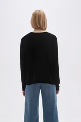 Sweater marrón de punto con textura trenzada, cuello redondo y mangas largas.