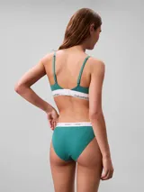 Conjunto Calvin Klein de ropa interior, compuesto por un corpiño triangular de algodón acanalado color verde esmeralda con elástico blanco con logo de la marca y una tanga de algodón acanalado color verde esmeralda con elástico blanco con logo de la marca.