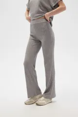 Pantalón gris de poliéster y lurex, holgado y de tiro alto, con textura acanalada.