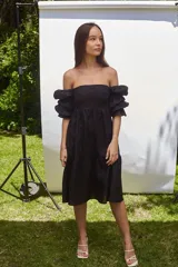 Vestido corto blanco de lino, con escote recto, mangas abullonadas 3/4 con elástico y falda con volado.