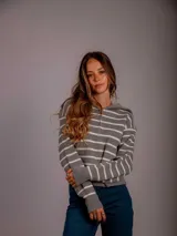 Buzo gris con rayas horizontales blancas, cuello alto con cierre y mangas largas.