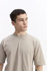 Remera lisa color beige de corte oversize, con escote redondo y mangas cortas.