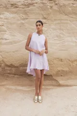 Vestido corto color beige, sin mangas y con cuello redondo.