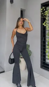 Catsuit negro con espalda descubierta y pantalones acampanados.