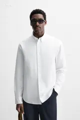 Camisa celeste de algodón, corte relaxed fit, cuello abotonado, manga larga con puños abotonados y cierre frontal con botones.